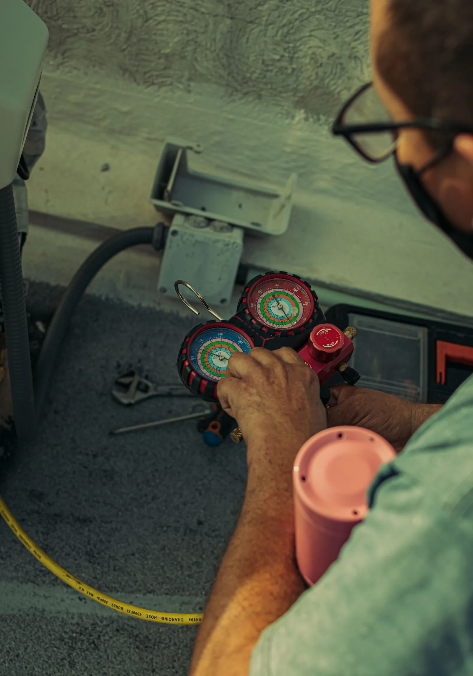 Technician checking refrigerant pressure gauges during cold-chain equipment servicing
