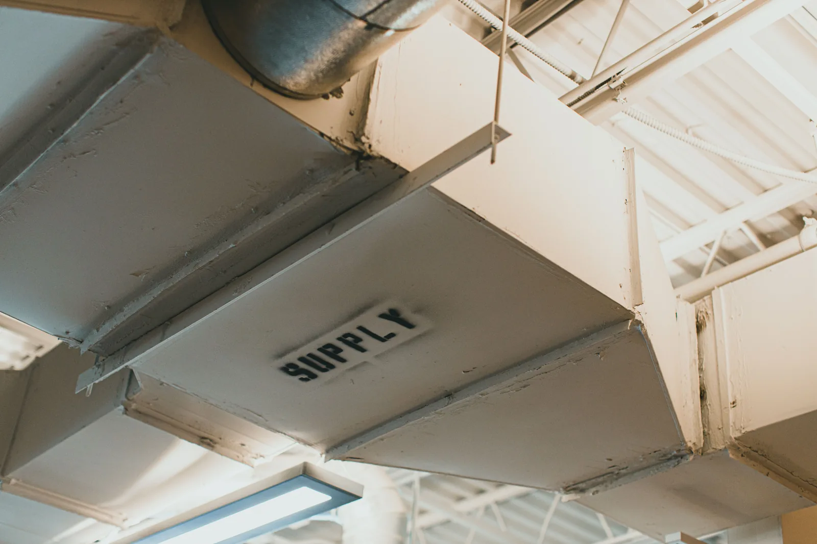 Labelled 'SUPPLY' ventilation duct running through a commercial ceiling void